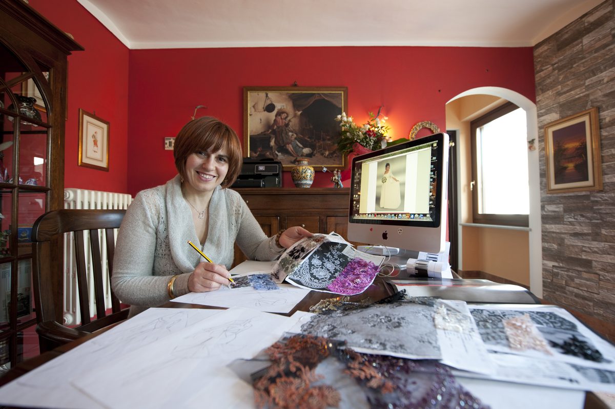 Francesca Surace al tavolo da lavoro, tra campioni di pizzo e bozzetti